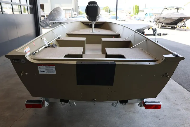 Slide: The Image of 2025 Lund SSV-18 Tiller boat in showroom, rear view, showcasing interior layout. - 6