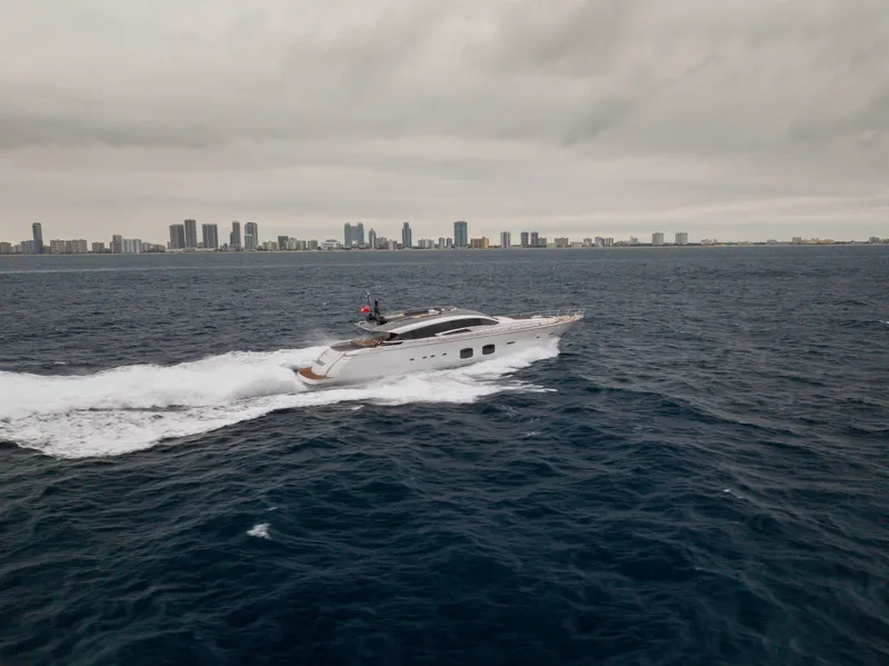 Slide: The Image of 2018 Pershing 108 yacht cruising on ocean with city skyline in background. - 19