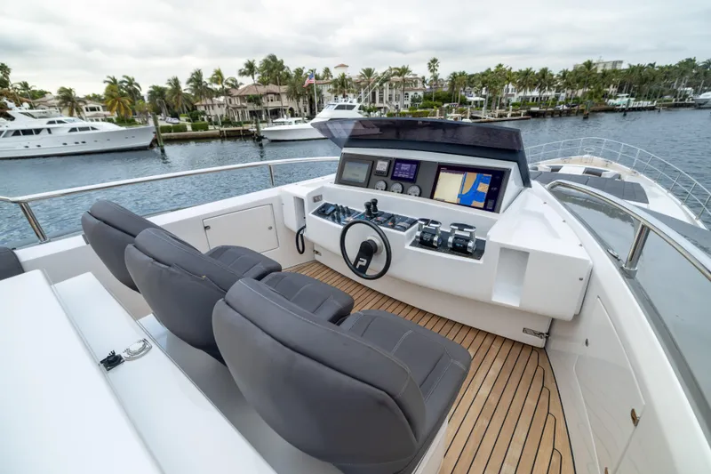 Slide: The Image of Flybridge of 2018 Pershing 108 yacht with modern controls and seating, docked in marina. - 26