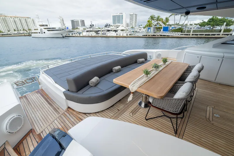 Slide: The Image of Luxurious 2018 Pershing 108 yacht deck with seating and dining area, docked at marina. - 34