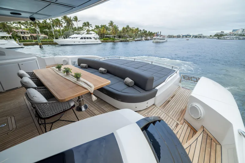 Slide: The Image of Luxurious 2018 Pershing 108 yacht deck with seating and dining area, overlooking serene waterfront. - 35
