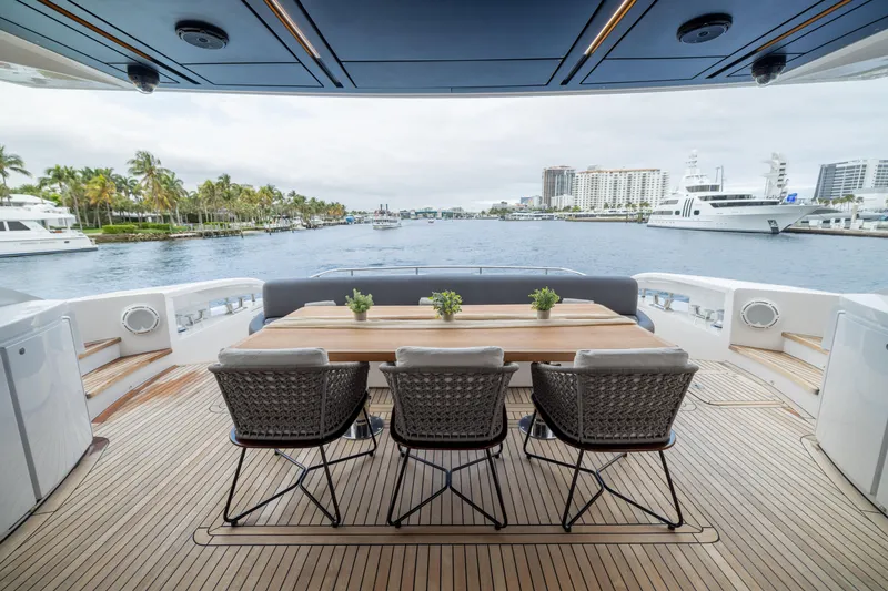 Slide: The Image of Luxury Pershing 108 yacht deck with dining area, overlooking marina and waterfront views. - 36