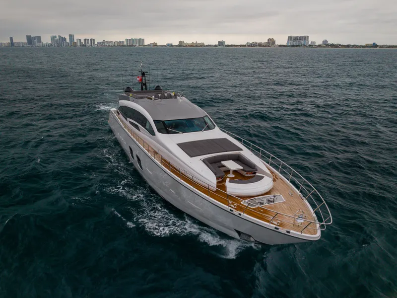 Slide: The Image of Luxury 2018 Pershing 108 yacht cruising on open water near city skyline. - 4