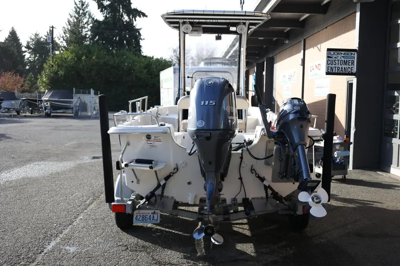 Slide: The Image of 2013 Carolina Skiff 178 DLV boat with dual outboard motors in a marina setting. - 5