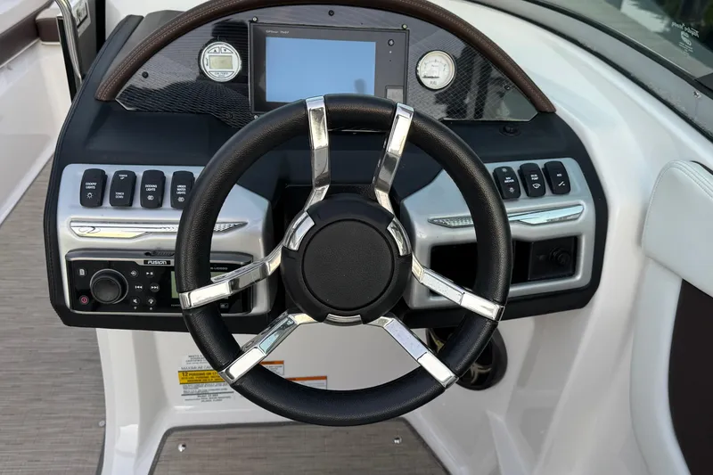 Slide: The Image of Steering wheel and dashboard of 2016 Regal 23 OBX boat, featuring modern controls. - 10