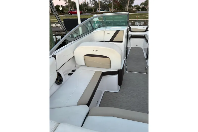 Slide: The Image of 2016 Regal 23 OBX boat interior with white and beige seating, docked near water. - 20