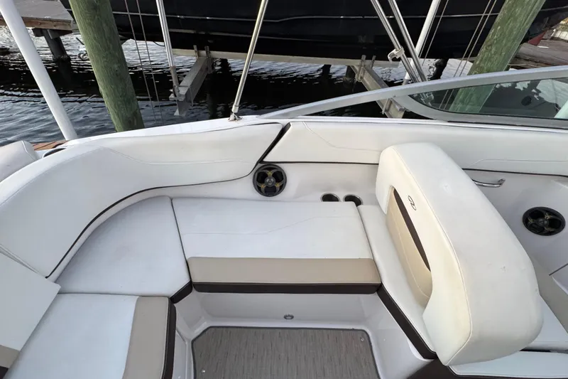 Slide: The Image of 2016 Regal 23 OBX boat interior with white seating and cup holders. - 26