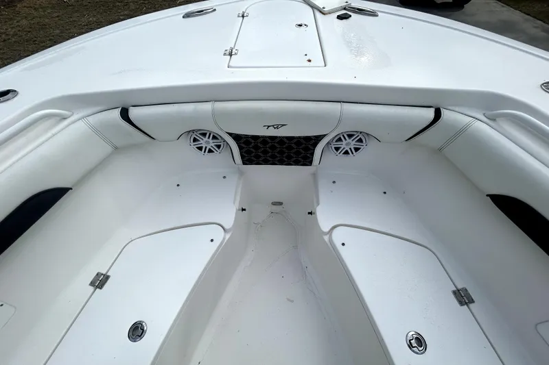 Slide: The Image of 2022 Tidewater 256 CC Adventure boat interior with white seating and storage compartments. - 14