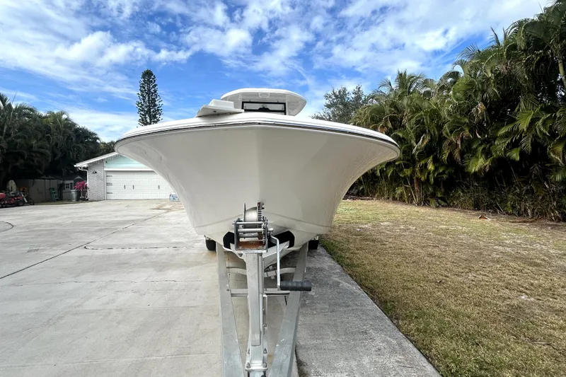 Slide: The Image of 2022 Tidewater 256 CC Adventure boat on trailer, driveway setting, clear sky. - 17