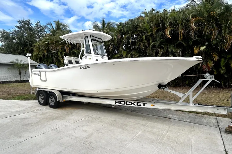 Slide: The Image of 2022 Tidewater 256 CC Adventure boat on trailer, parked outdoors. - 21
