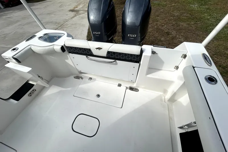 Slide: The Image of 2022 Tidewater 256 CC Adventure boat deck with twin 150 engines, spacious layout. - 4