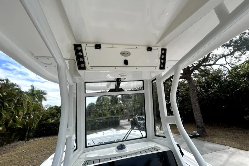 Slide: The Image of 2022 Tidewater 256 CC Adventure boat interior with console and overhead storage. - 7