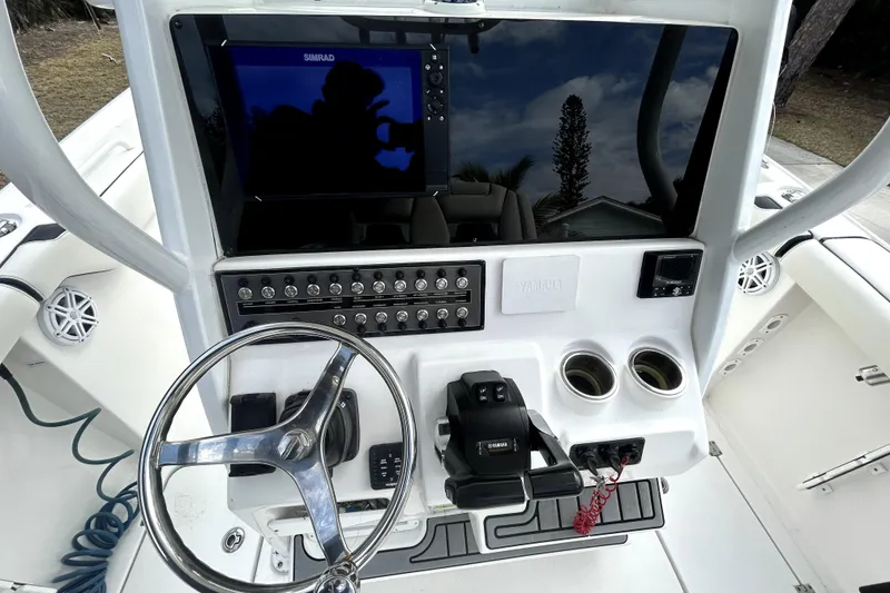 Slide: The Image of 2022 Tidewater 256 CC Adventure boat dashboard with steering wheel and controls. - 8