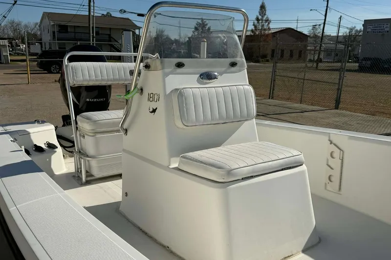 Slide: The Image of 2007 Mako 1801 Inshore boat interior with seating and console, parked outdoors. - 6
