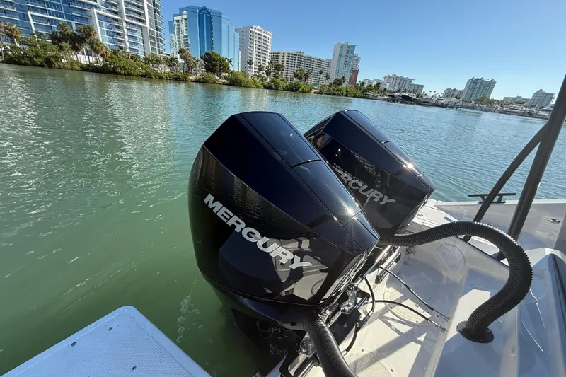 Slide: The Image of Twin Mercury outboard engines on a Navan C30 boat, 2026 model, in a scenic waterfront setting. - 14