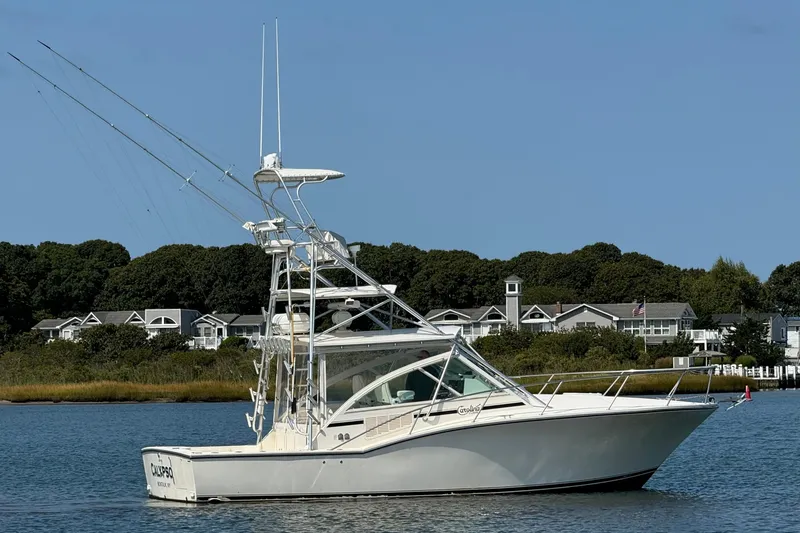The Image of 2007 Carolina Classic 35 Express boat on calm water near shoreline homes. - 0