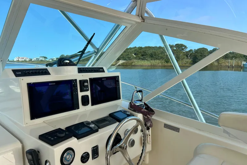 Slide: The Image of 2007 Carolina Classic 35 Express helm with dual displays, steering wheel, and scenic water view. - 11