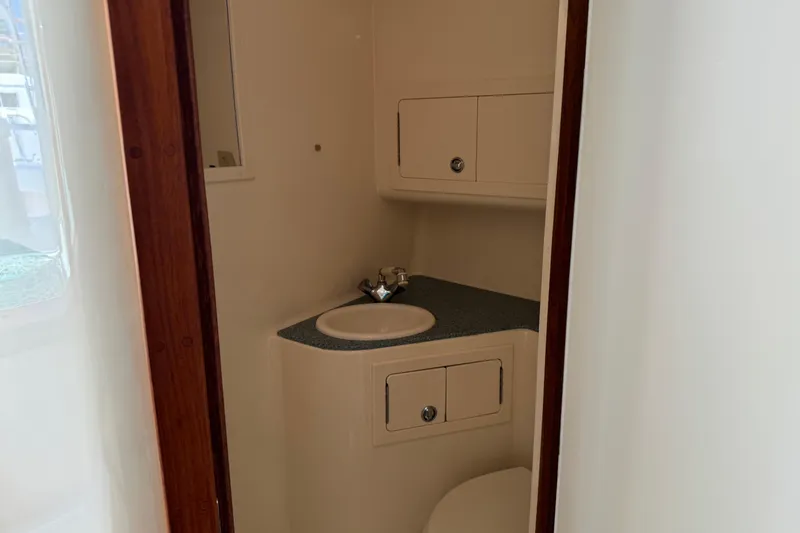 Slide: The Image of 2007 Carolina Classic 35 Express boat bathroom with sink and storage cabinets. - 17
