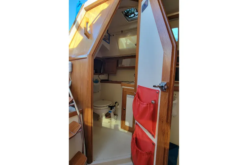Slide: The Image of Interior of 1993 Catalina 28 sailboat showing compact bathroom with wooden accents. - 24