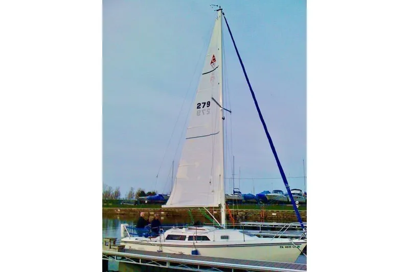 Slide: The Image of 1993 Catalina 28 sailboat docked, featuring tall mast and white sails. - 31
