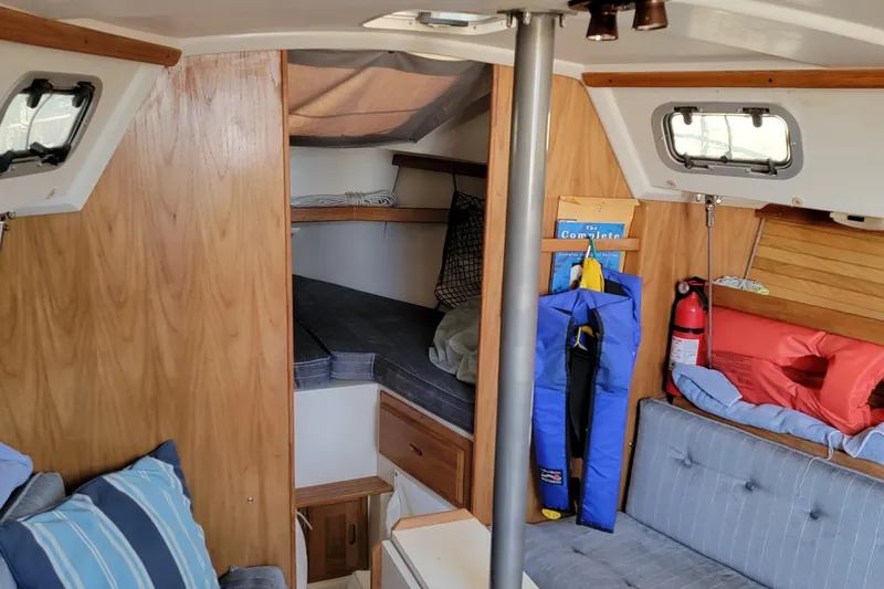 Slide: The Image of Interior of a 1993 Catalina 28 sailboat with cozy seating and safety equipment. - 14