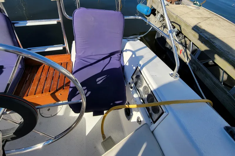 Slide: The Image of Cockpit of a 1993 Catalina 28 sailboat with purple cushions and wooden accents. - 28