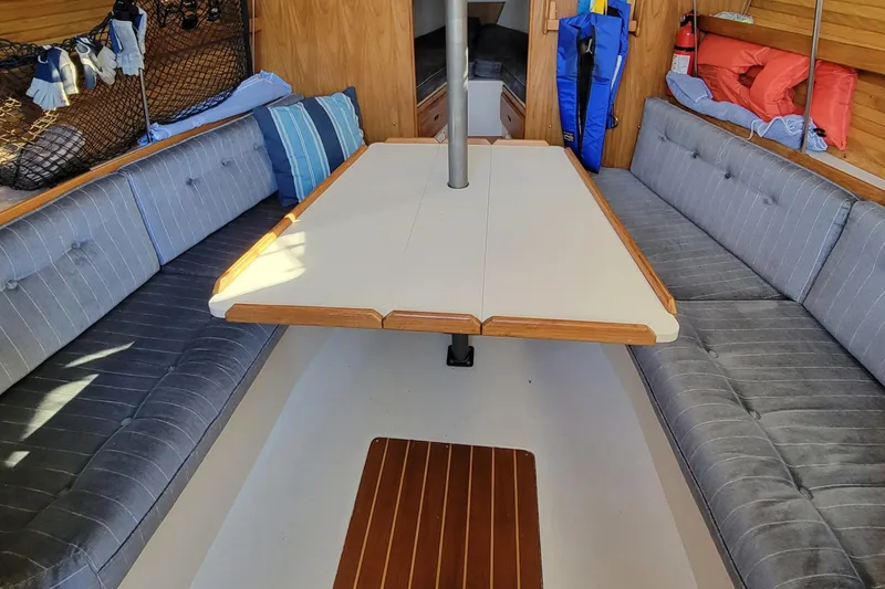 Slide: The Image of Interior of a 1993 Catalina 28 sailboat with cushioned seating and a central table. - 26