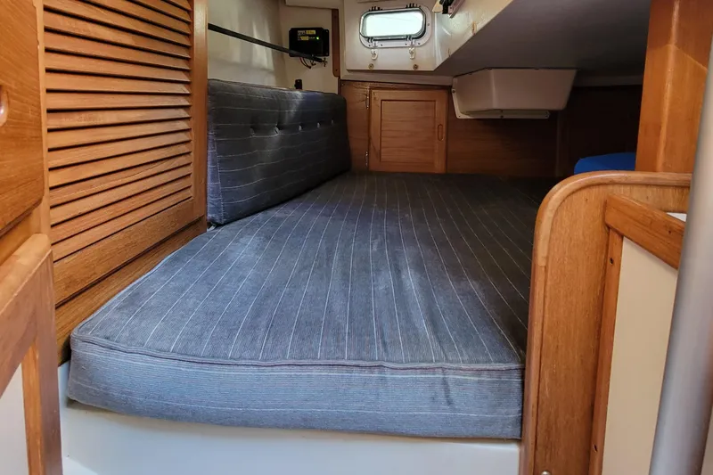 Slide: The Image of Cozy cabin interior of 1993 Catalina 28 sailboat with wooden accents and cushioned seating. - 18