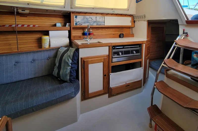 Slide: The Image of Interior of a 1993 Catalina 28 sailboat with cozy seating and compact kitchen area. - 17