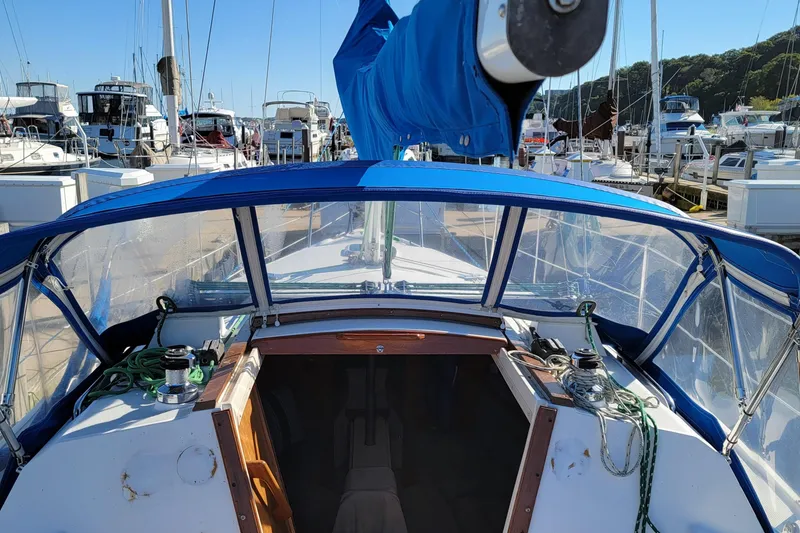 Slide: The Image of 1993 Catalina 28 sailboat cockpit with blue canopy, docked at marina. - 11