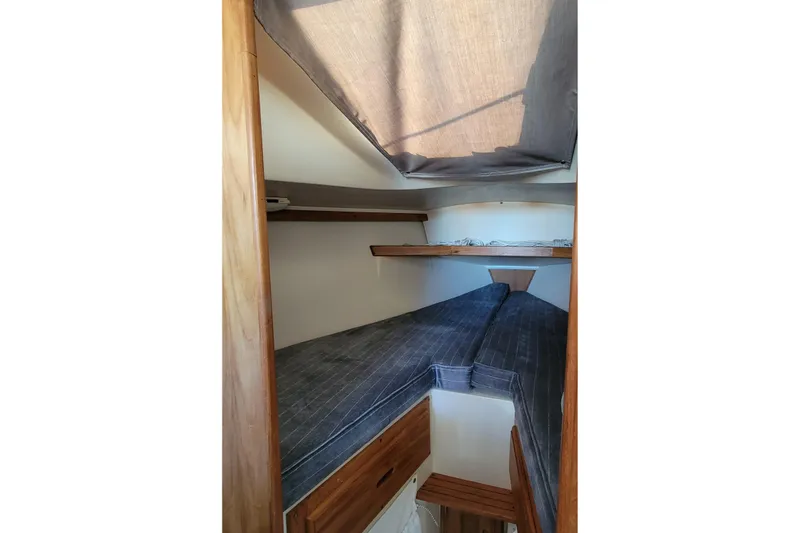 Slide: The Image of 1993 Catalina 28 sailboat interior cabin with wooden accents and cozy sleeping area. - 23