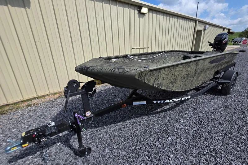 Slide: The Image of 2026 Tracker Grizzly 1650 T Prairie Wings Edition boat on trailer, parked on gravel. - 8