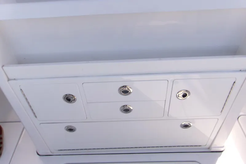 Slide: The Image of 2025 Sportsman Open 322 Center Console storage compartment with sleek white finish and metal handles. - 32