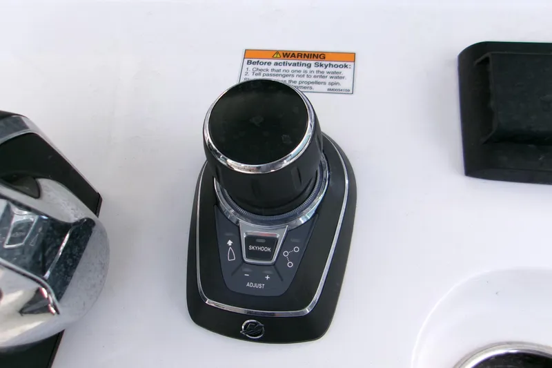 Slide: The Image of 2025 Sportsman Open 322 Center Console joystick control with Skyhook feature and warning label. - 7