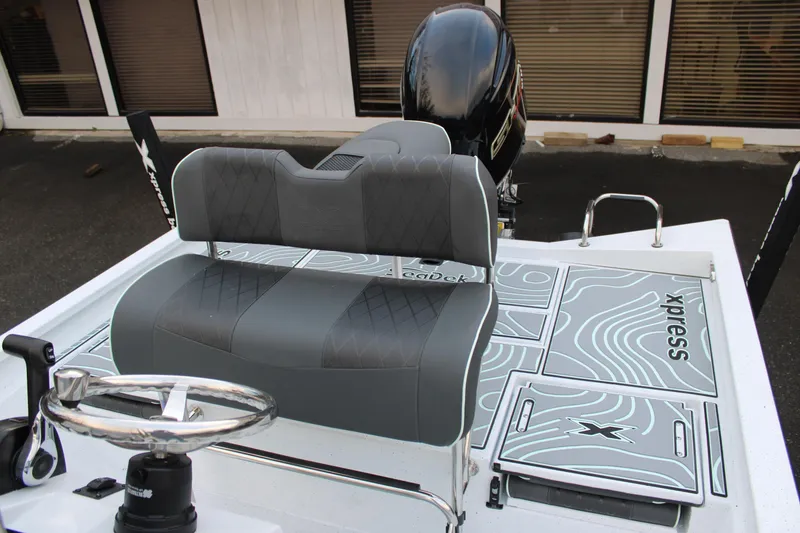 Slide: The Image of 2026 Xpress H22B Bay boat interior with gray seating and steering wheel. - 10