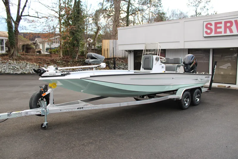 Slide: The Image of 2026 Xpress H22B Bay boat on trailer, parked outdoors near service center. - 2