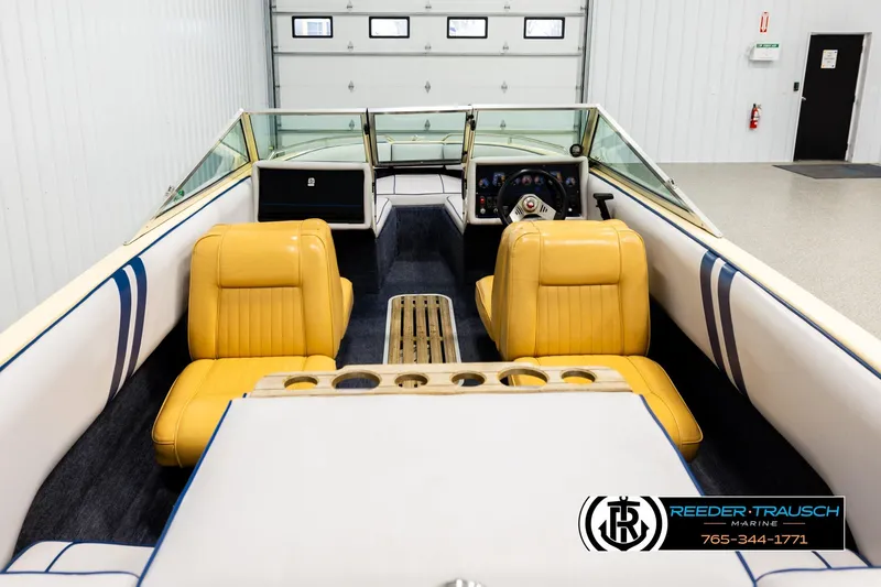 Slide: The Image of 1988 Celebrity 180 V boat interior with yellow seats and steering wheel, in a garage setting. - 11
