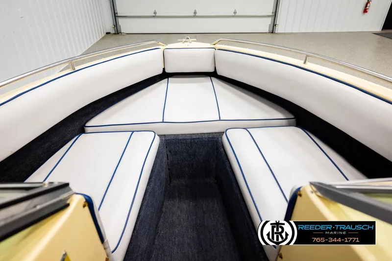 Slide: The Image of Interior of 1988 Celebrity 180 V boat with white cushioned seating and blue trim. - 23