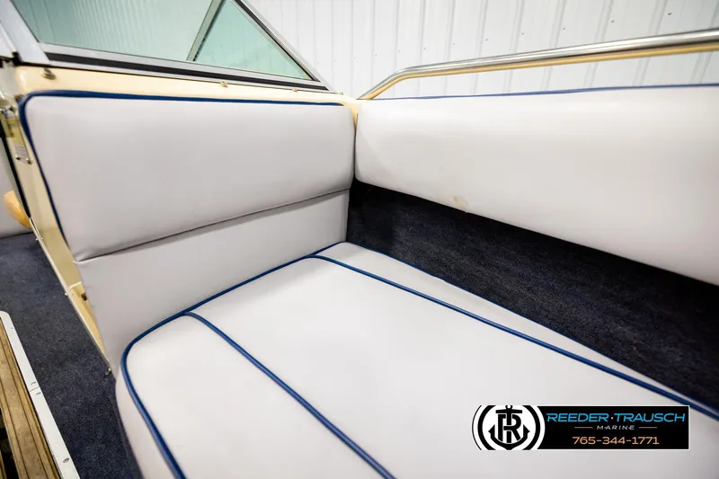 Slide: The Image of Interior seating of a 1988 Celebrity 180 V boat with white upholstery and blue trim. - 32