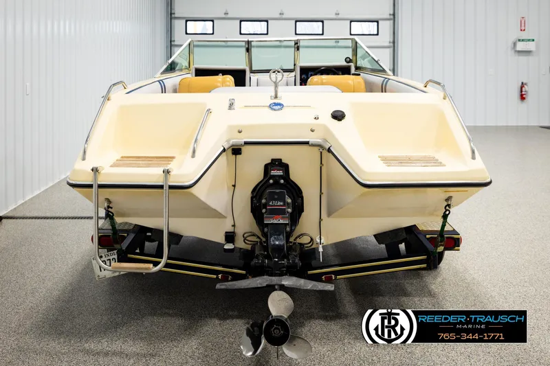 Slide: The Image of 1988 Celebrity 180 V boat in showroom, rear view with propeller and trailer. - 5