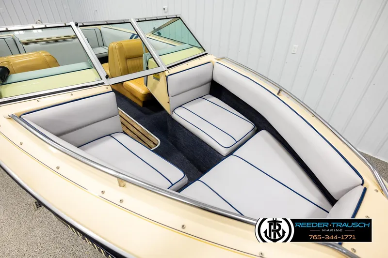 Slide: The Image of 1988 Celebrity 180 V boat interior with white and blue seating, Reeder-Trausch Marine logo. - 7