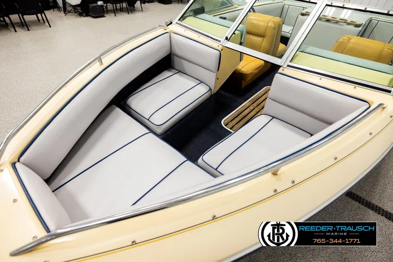 Slide: The Image of 1988 Celebrity 180 V boat interior with white and blue seating, Reeder-Trausch Marine logo. - 8