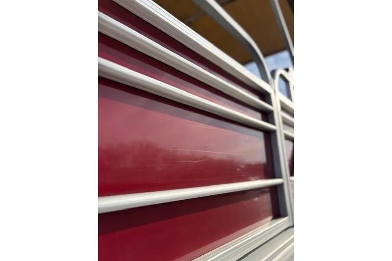 Slide: The Image of Close-up of 2023 Sun Tracker Party Barge 22 DLX red exterior with metal railings. - 10