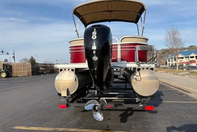 Slide: The Image of 2023 Sun Tracker Party Barge 22 DLX pontoon boat with outboard motor, parked on trailer. - 11
