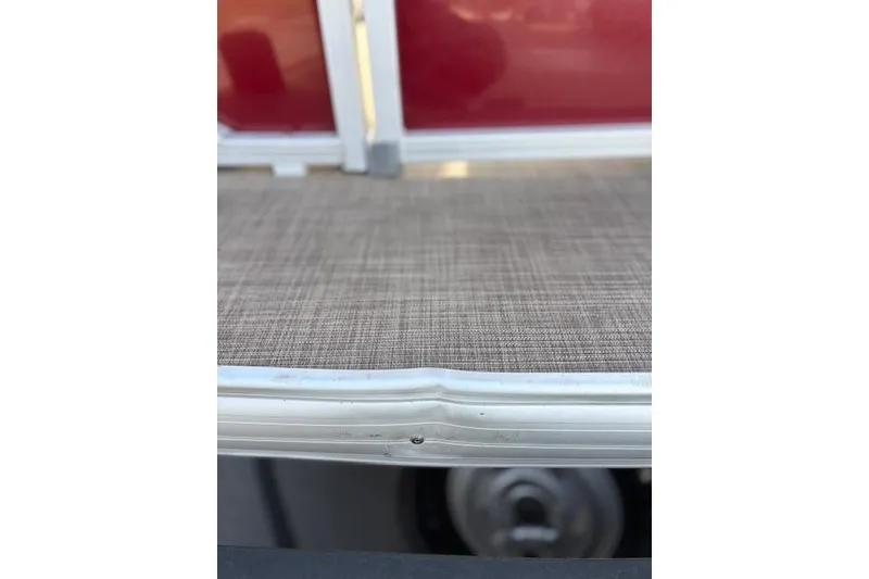 Slide: The Image of 2023 Sun Tracker Party Barge 22 DLX deck with textured flooring and red paneling. - 12