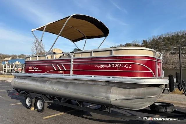 Slide: The Image of 2023 Sun Tracker Party Barge 22 DLX pontoon boat on trailer, red and beige design. - 6