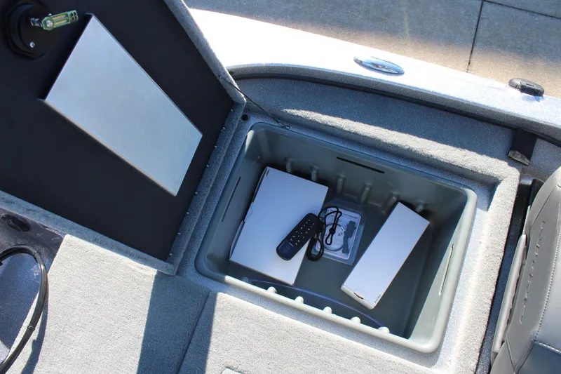 Slide: The Image of Open storage compartment in 2026 Nitro Z18 Pro boat with remote and accessories. - 17