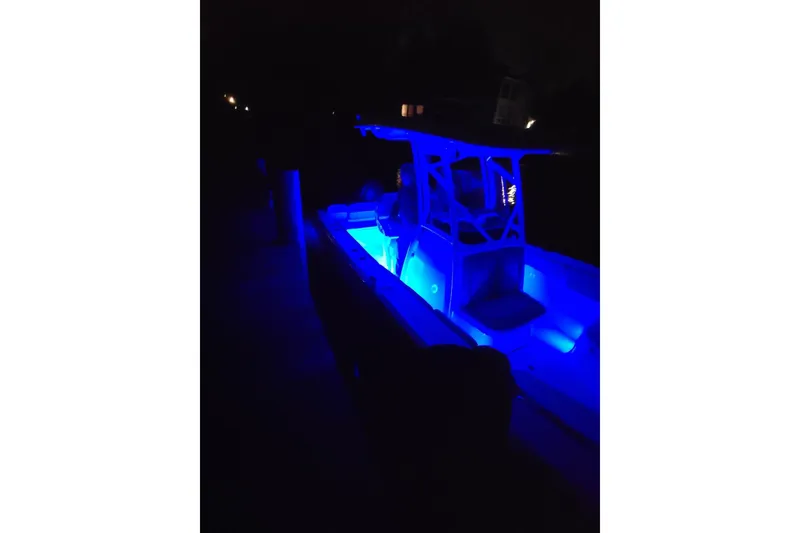 Slide: The Image of 2022 Sea Fox 248 Commander boat illuminated with blue LED lights at night. - 18