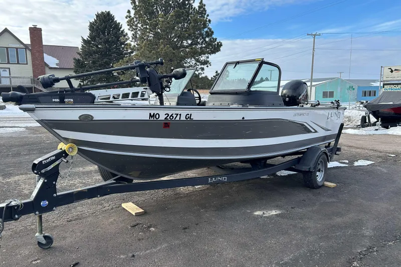 Slide: The Image of 2020 Lund 1875 Impact fishing boat on trailer, parked outdoors in winter setting. - 1