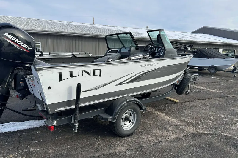 Slide: The Image of 2020 Lund 1875 Impact boat on trailer with Mercury engine, parked outdoors. - 4